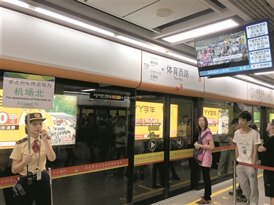 地鐵工作人員現場舉牌指引乘客乘坐貫通車