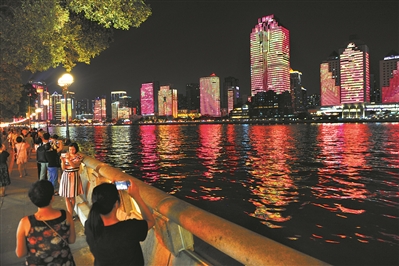 在濱江路散步的市民紛紛拿起手機(jī)拍攝對(duì)岸的美景。