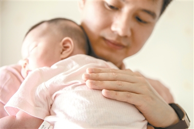 賴永新化身溫柔奶爸，抱著剛出生小女兒哄她入睡。