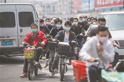 中大布匹市場附近，工人們戴著口罩返工。