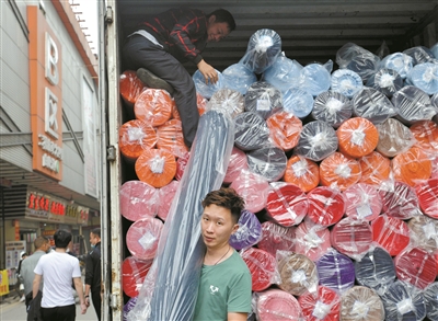 處于紡織商圈核心位置的廣州國際輕紡城，貨物裝滿車廂，工人忙著出貨。