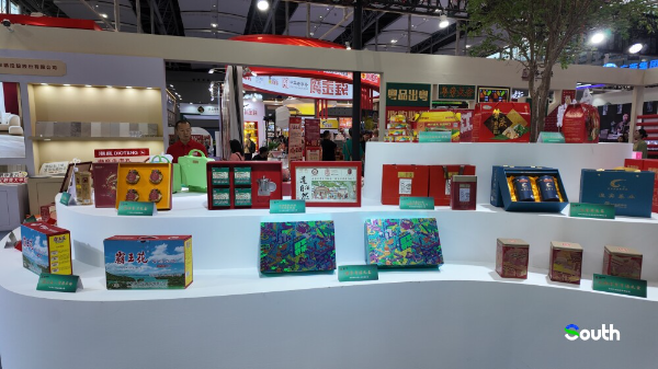 Curated display of regional specialties including Heyuan rice noodles, fermented black soybean, zongzi, etc.